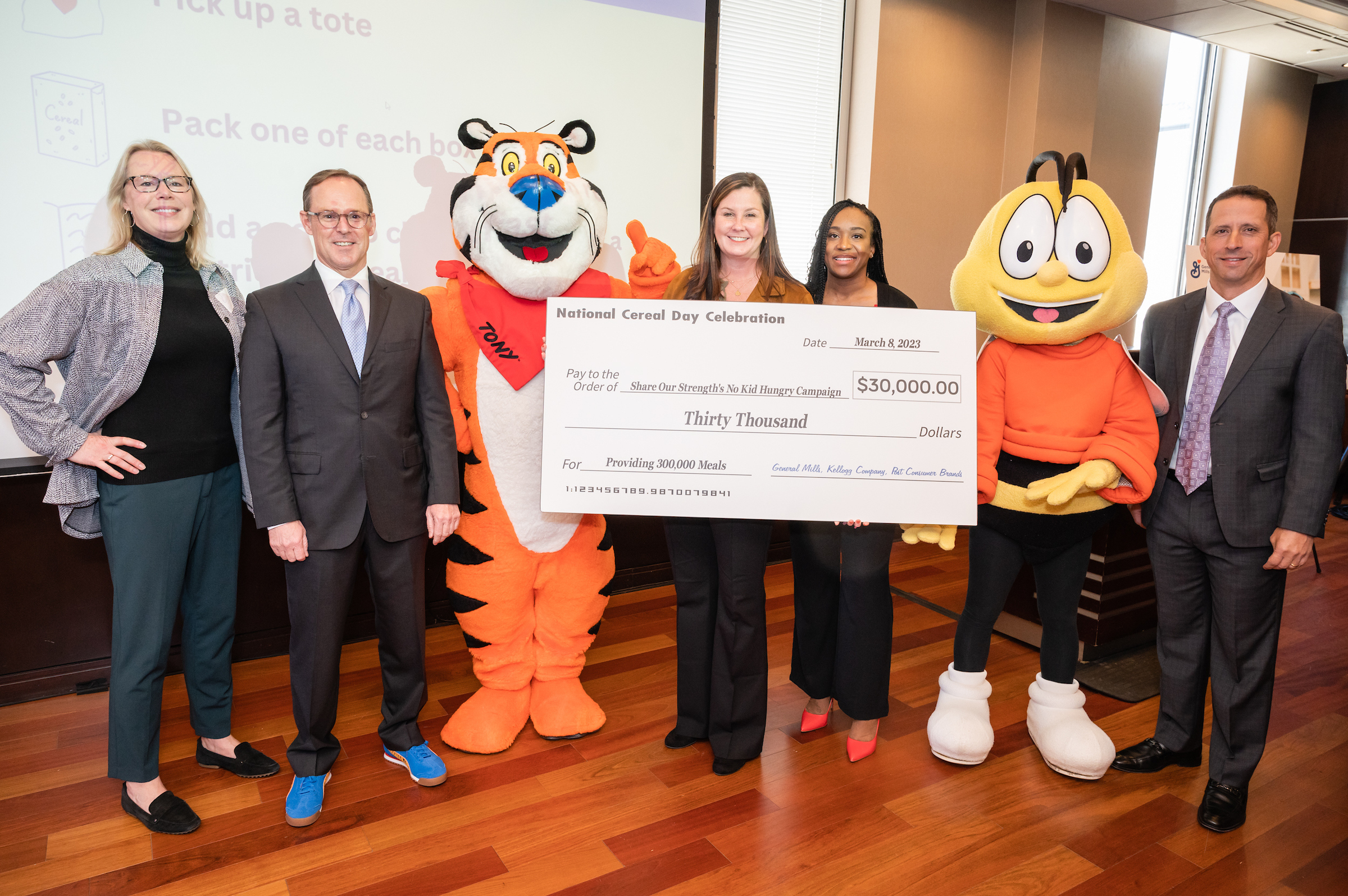 Team presenting a check to No Kid Hungry to help provide meals to kids